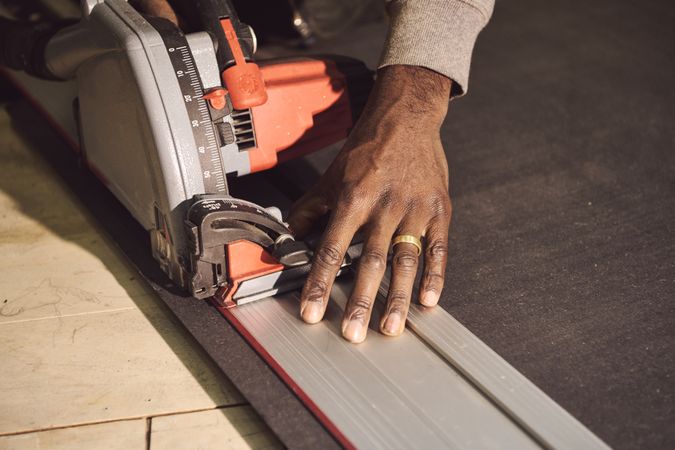 Hands of a Black male designer with saw
