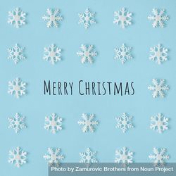 Snowflakes arranged on blue background with “Merry Christmas” 4N2mZ4