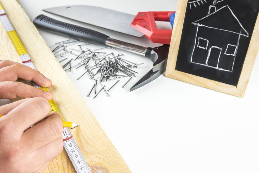 Builders hands measuring a wooden plank