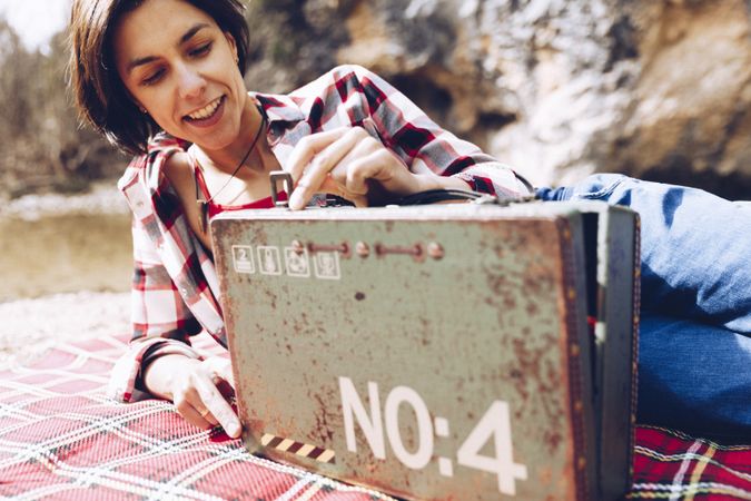 Cheerful woman with old case on picnic