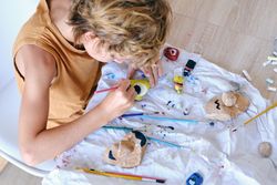 Child painting stone with aquarelle at home
