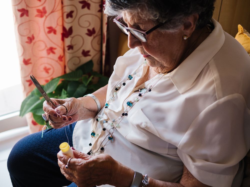 Mature woman with threads sitting at home
