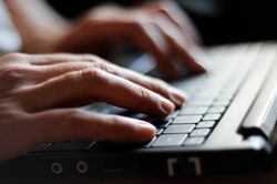 Close up of hands typing on keyboard of laptop