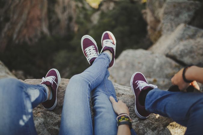 Casual couple resting together while sitting on high cliff