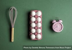 Cooking concept with pink egg box, whisk, and alarm clock 4MPkk5
