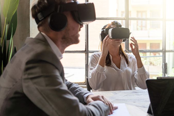 Two entrepreneurs having a metaverse remote meeting using VR googles