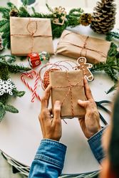 Crop person with Christmas gift box wrapped in paper
