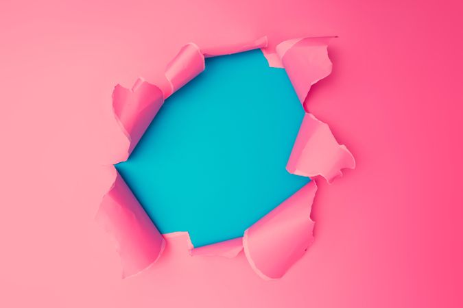 Torn pink paper revealing blue beneath