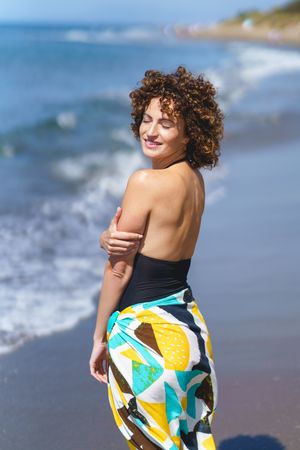 Woman in sarong standing on beach