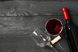 Flat lay composition with bottle of wine, glasses and corkscrew on wooden background, copy space