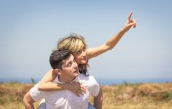 Happy guy carrying his girlfriend on back outdoors