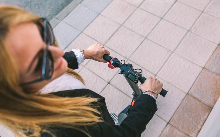 Top view of businesswoman with e-scooter outdoors