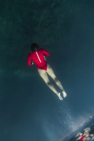 Woman diving in blue clean water