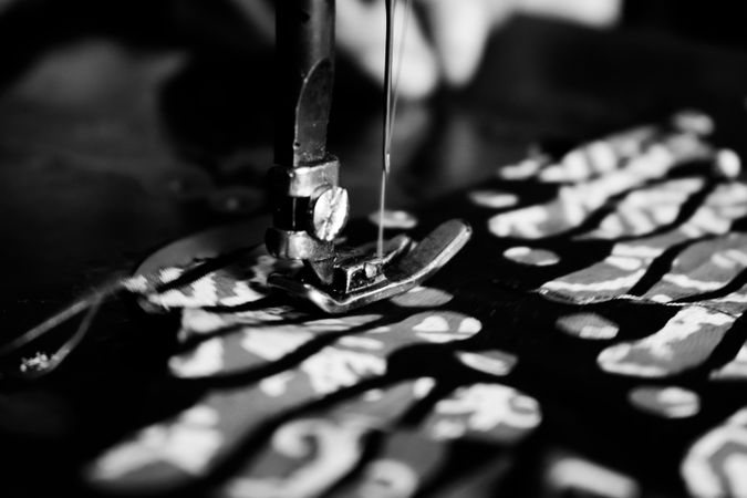 Close up of sewing machine needle working on batik Indonesian fabric