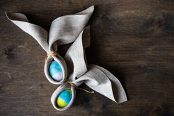 Two Easter eggs wrapped with rabbit ears with napkin