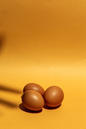 Fresh raw eggs on brown background