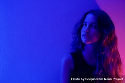 Portrait of pensive teenage girl in purple lit studio 4dWnn5