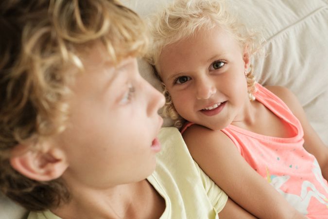 Content girl with sibling on sofa