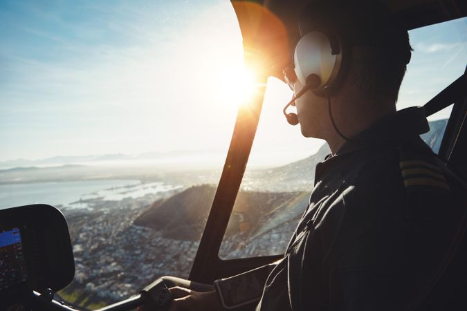 Side view of man looking away while flying helicopter over Cape Town