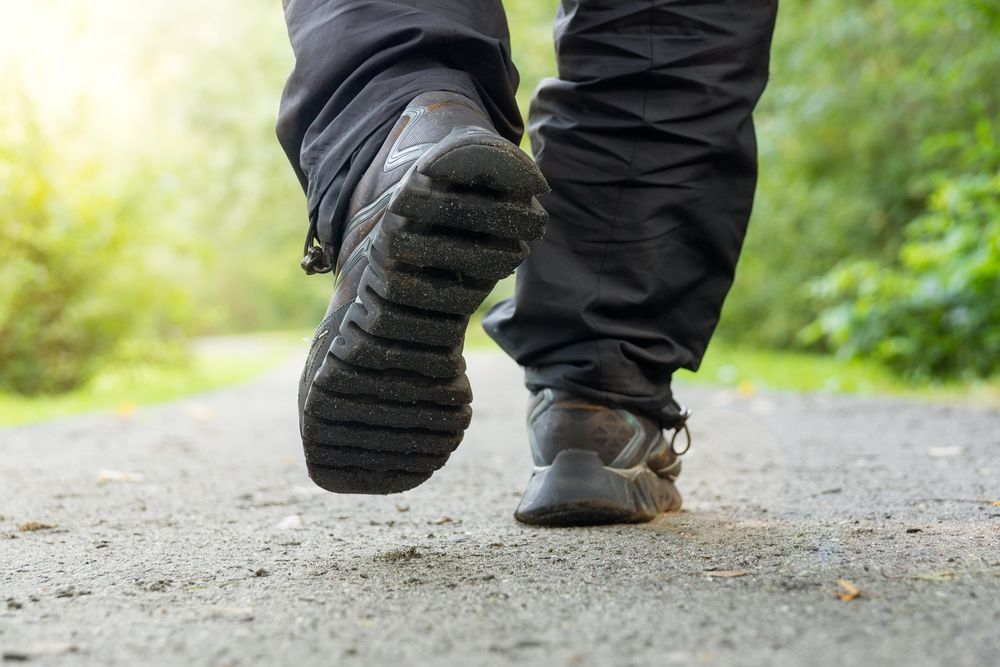 Person walking on pathway between grass