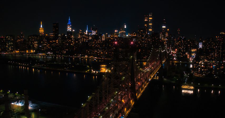 Aerial Helicopter Photo Over Ed Koch Queensboro Bridge with Manhattan Skyscrapers Cityscape. Beautiful Late Evening Shot Focusing on Upper East Side Office Buildings at Night