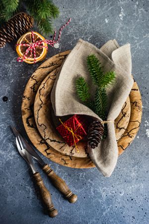 Top view of rustic Christmas table setting with decorative dried orange slices, and pine branch