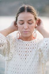 Feminine woman touching hair with closed eyes near sea