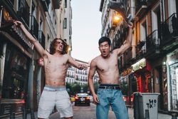 Rebellious shirtless multiracial men shouting while standing together on city street