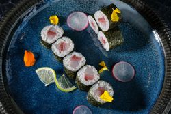Delicious sushi rolls on blue plate