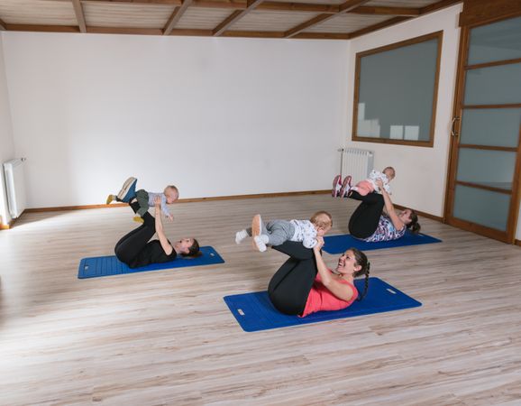 Mothers exercising with babies in gym