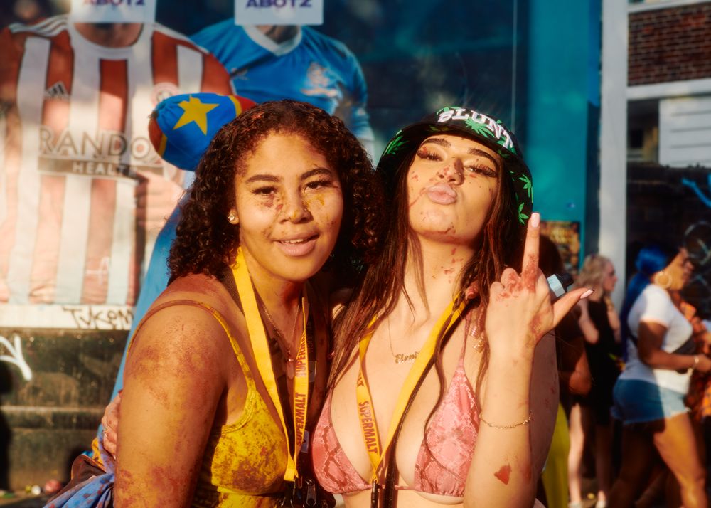 London, England, United Kingdom - August 27, 2022: Two young women splattered in paint on sunny day