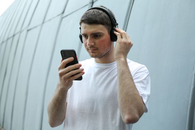 Young man in t-shirt listening to music in headphones