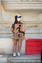 Los Angeles, CA, USA — June 16th, 2020: woman sitting on fountain at protest rally 4mWX70