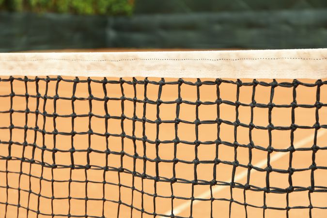 Clay tennis court with net, close up