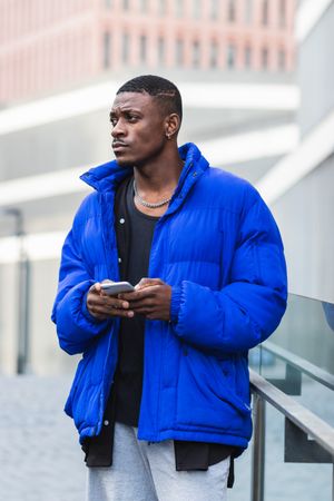 Stylish Black man chatting on social media on cellphone