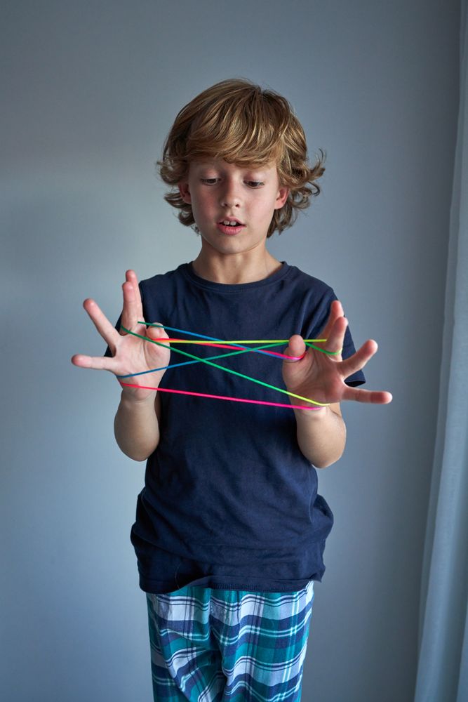Boy looking at rainbow finger rope