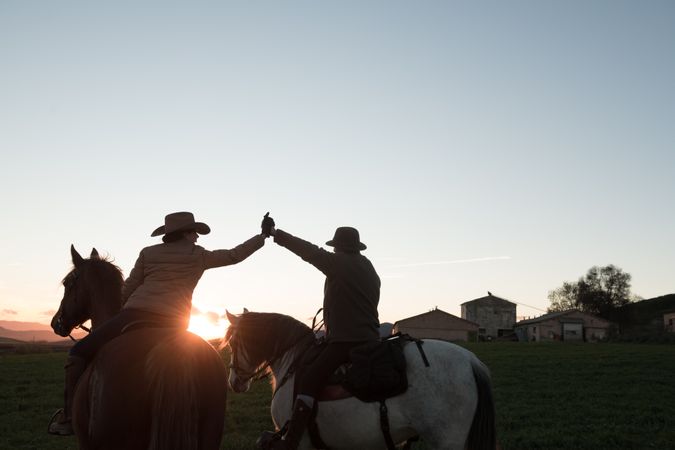 People on horses giving high five