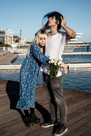 Woman hugging man with fish bowl on head