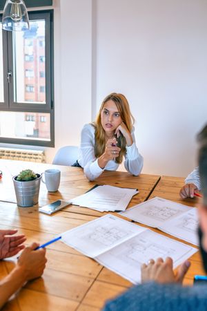 Businesswoman in a work meeting looking blueprints