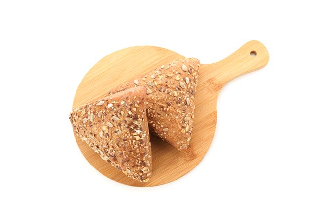 Triangular buns on cutting board isolated on plain background, top view. Bakery products