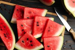Composition with board with watermelon slices on wooden table