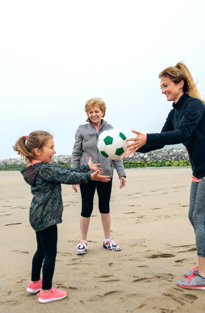 Three generations playing on the beach