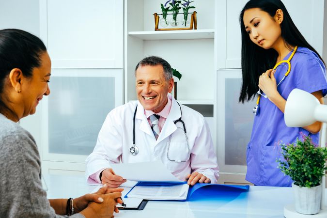 Smiling doctor making patient laugh in office