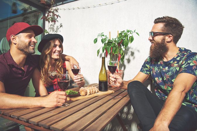 Bearded man with couple drinking wine in summer