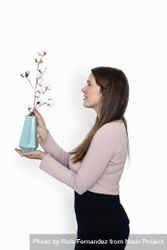 Side view of a woman holding a plant 0KMB1Z