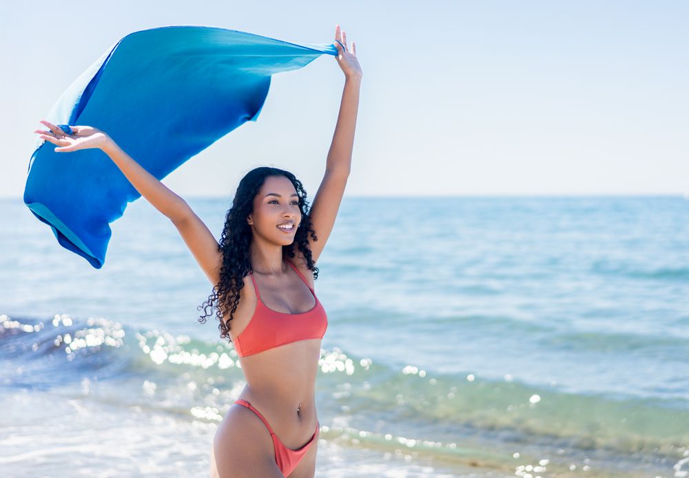 Experience a Joyful Beach Moment with a Flowing Silk Shawl and Vibrant Surroundings