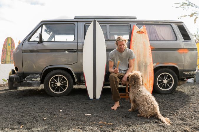 Man standing near surf boards and van