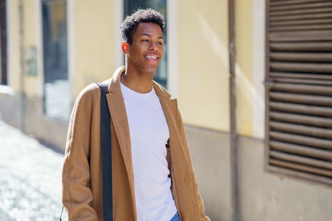 Smiling Cuban male strolling down street, copy space