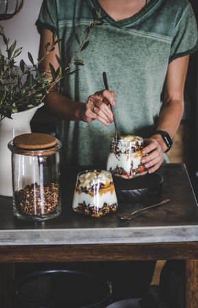 Woman eating yogurt parfait on rustic table