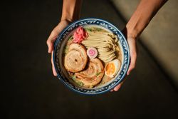 Crop female with bowl of ramen in hands
